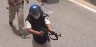 बिहार के सीवान में प्रदर्शनकारियों से निपटने में एके 47 तानता हुआ पुलिसकर्मी